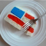 slice of american flag style cake on white platter with fork