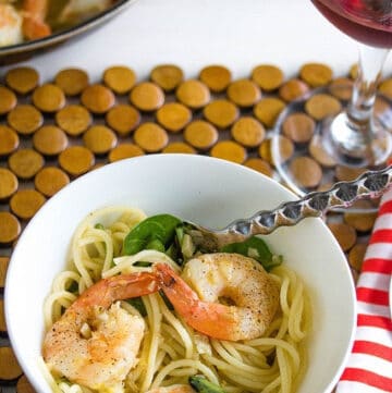 top view of shrimp scampi in white bowl with spoon