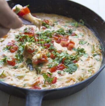A simple queso loaded with tomato, onion, and peppers