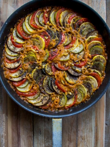 top view of slow roasted ratatouille in black pan on wooden board
