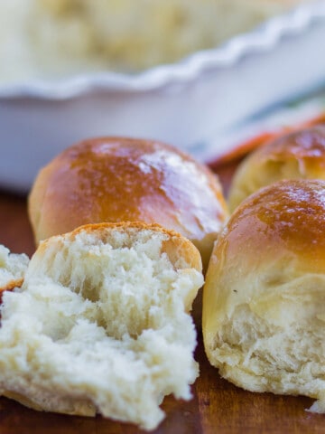 close up view of dinner rolls with one torn open