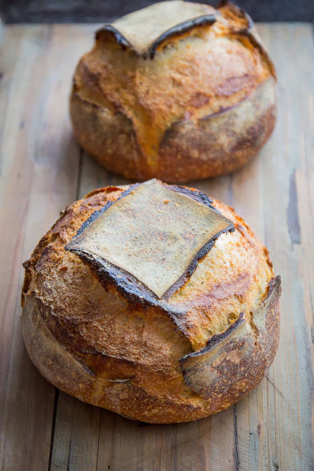 2 round loaves of tartine recipe bread on wood board