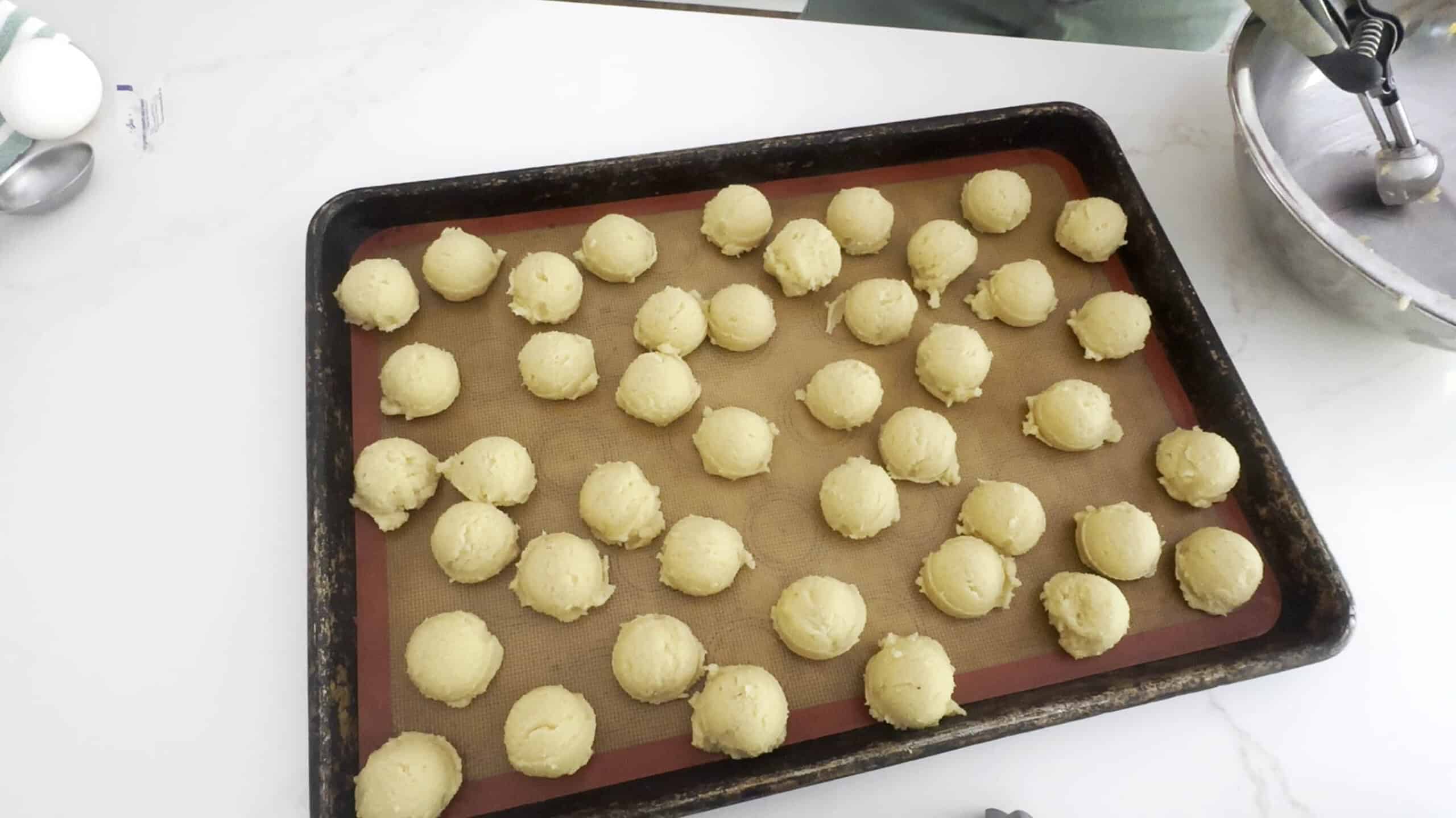 Tray of cookie dough shaped into balls. 
