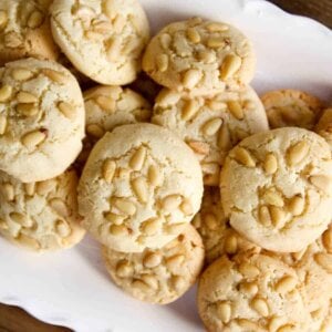 top view of freshly baked pignoli cookies on white serving platter