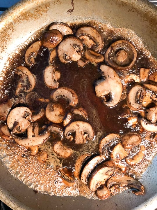 mushrooms with marsala wine cooking on stovetop