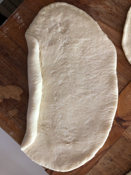 rolling dough into shaped rolls for sandwiches