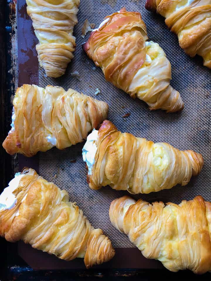 Several lobster tail pastries on a baking sheet. 