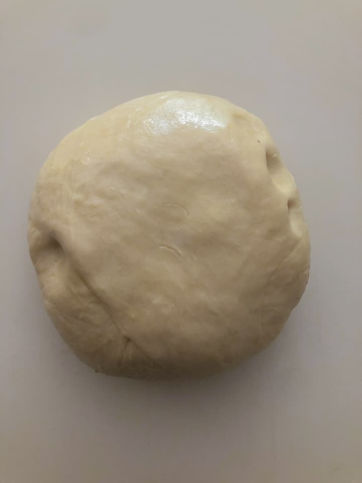 Dough in round shape on counter. 