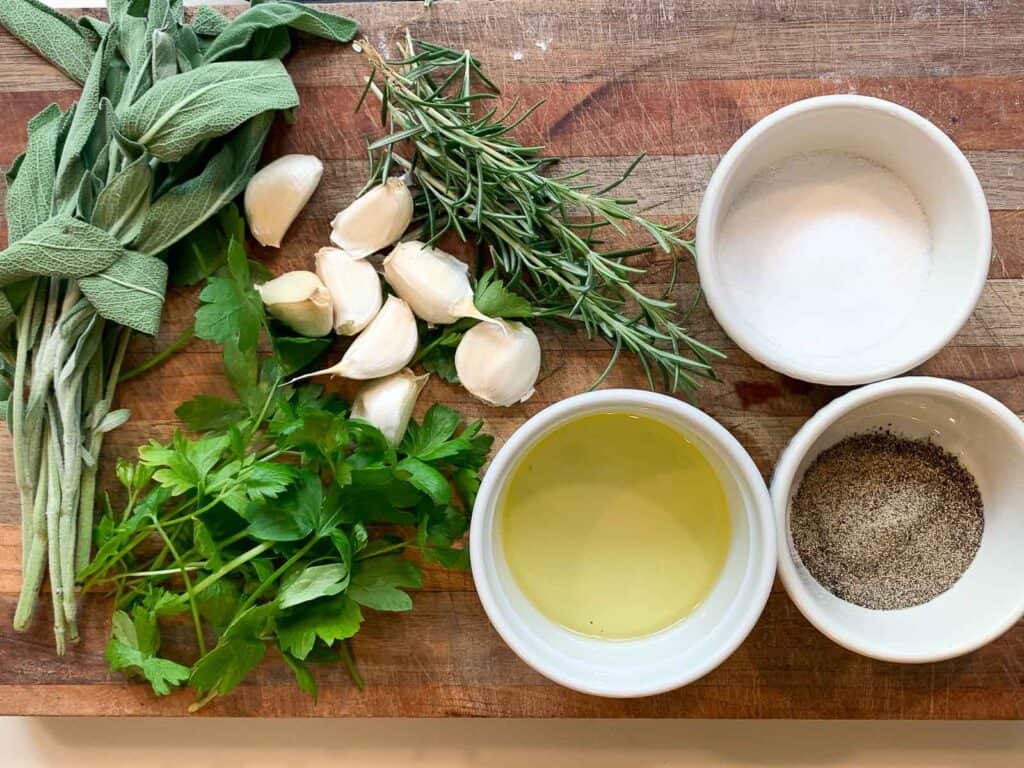 overhead view of seasoning ingredients for philly roast pokr (herbs, salt, pepper, fresh garlic, and olive oil
