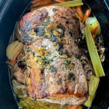 top view of philadelphia roast pork in black pan with veggies