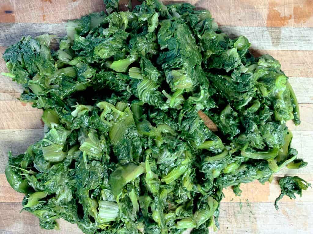 cooked escarole on wooden board