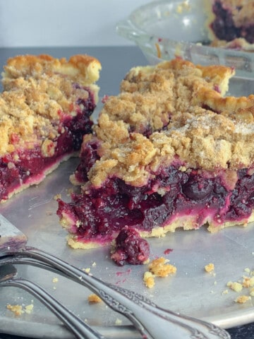 side view of three slices of mixed berry pie on plate with fork