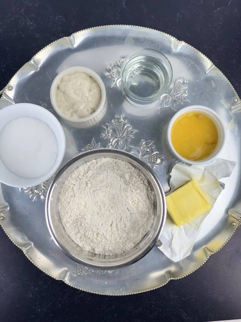 overhead view of panettone ingredients measured out and shown on silver tray