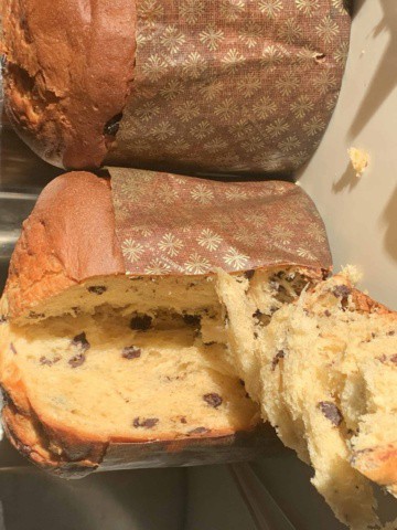 side view of panettone with one slice in forefront
