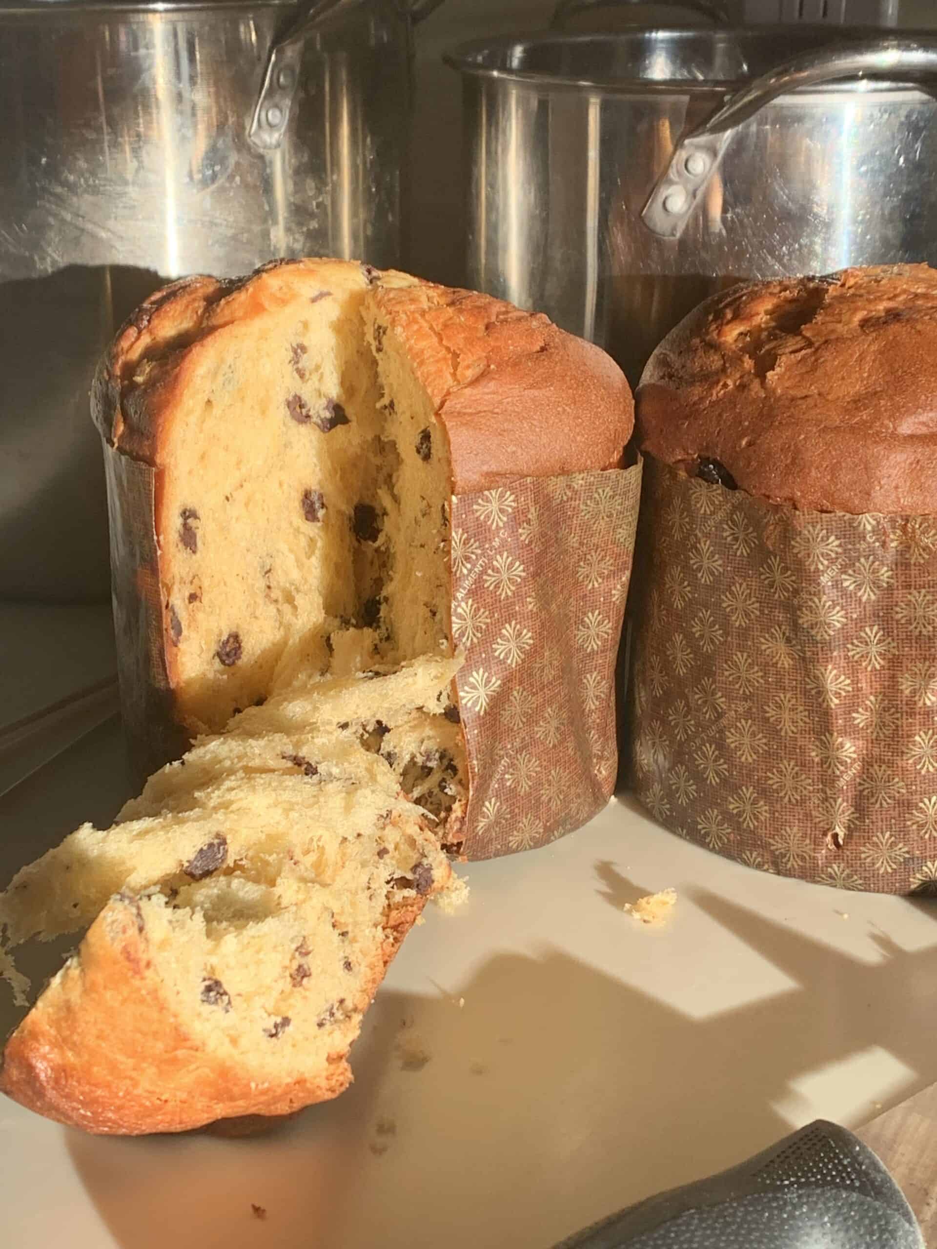 side view of panettone with one slice in forefront