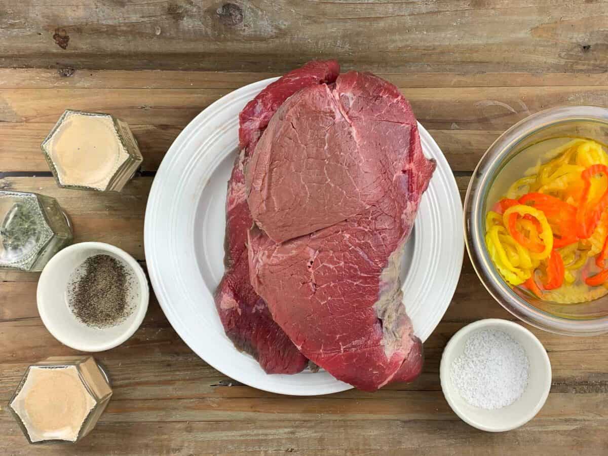 spices, steak, and sliced peppers on wooden board ingredients How To Make Instant Pot Italian Beef