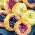 close up view of fruit and cheese kolache on black plate