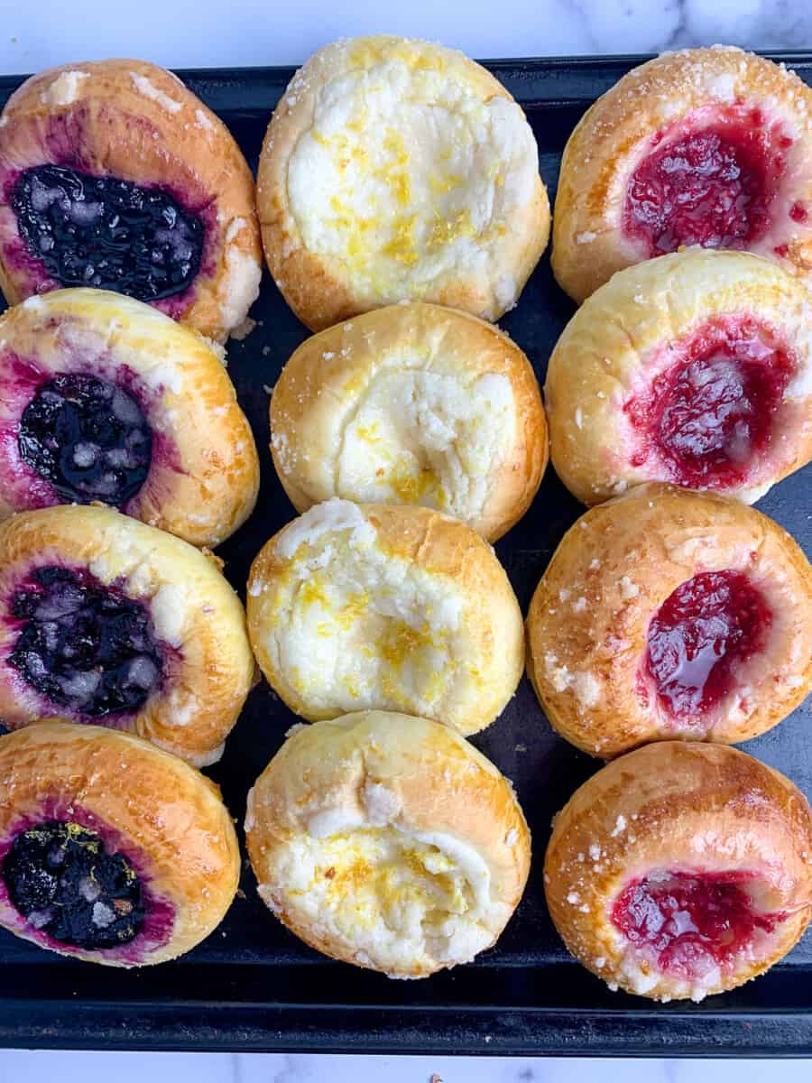 top view of baked kolache with fruit on black tray