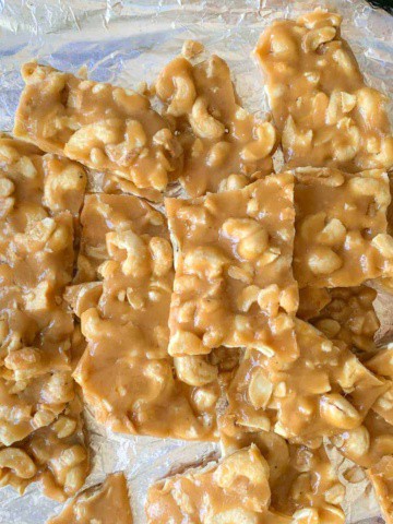 top view of cashew brittle on aluminum foil lined baking sheet