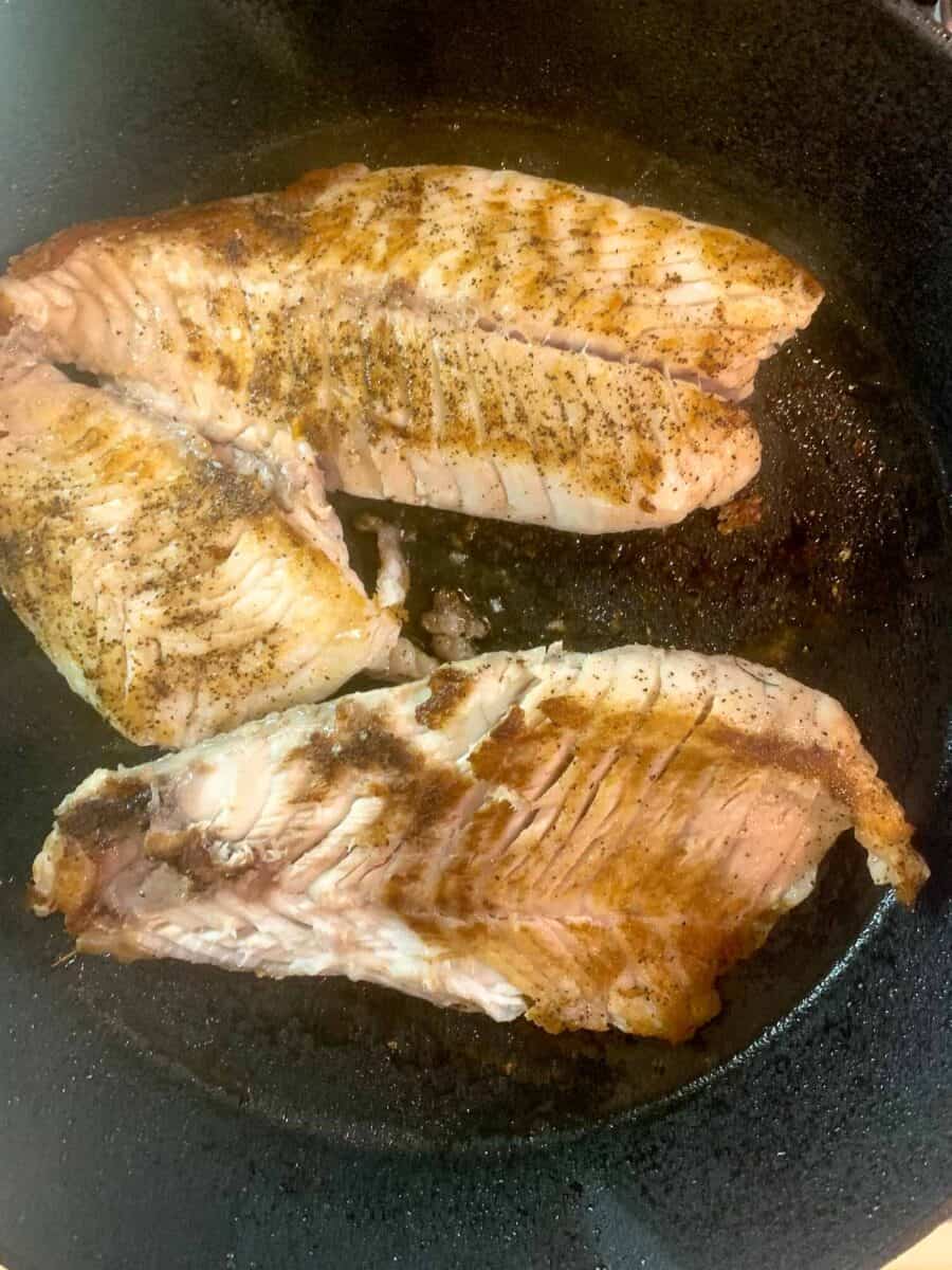 white fish in cast iron pan after cooking