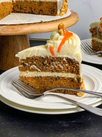 slice of carrot cake on white plate with fork