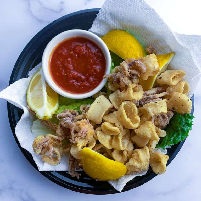 plate of fried calamari rings with red sauce