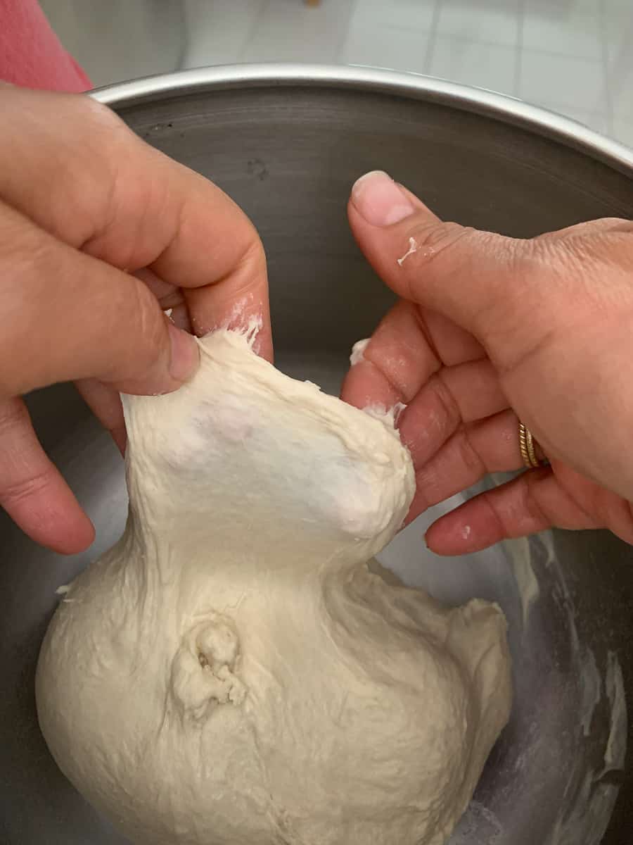 pulling a windowpane showing dough is mixed adequately