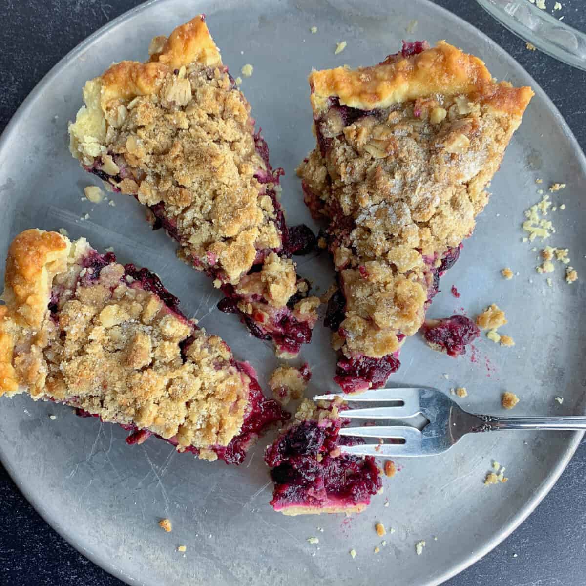 top view of 3 slices of mixed berry pie on silver dish with forks