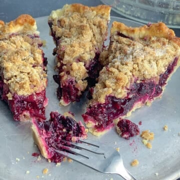 top view of 3 slices of mixed berry pie on silver dish with forks
