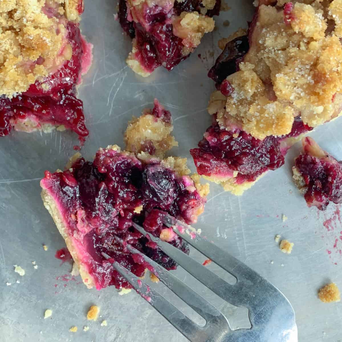 close up view of one piece of mixed berry pie with fork