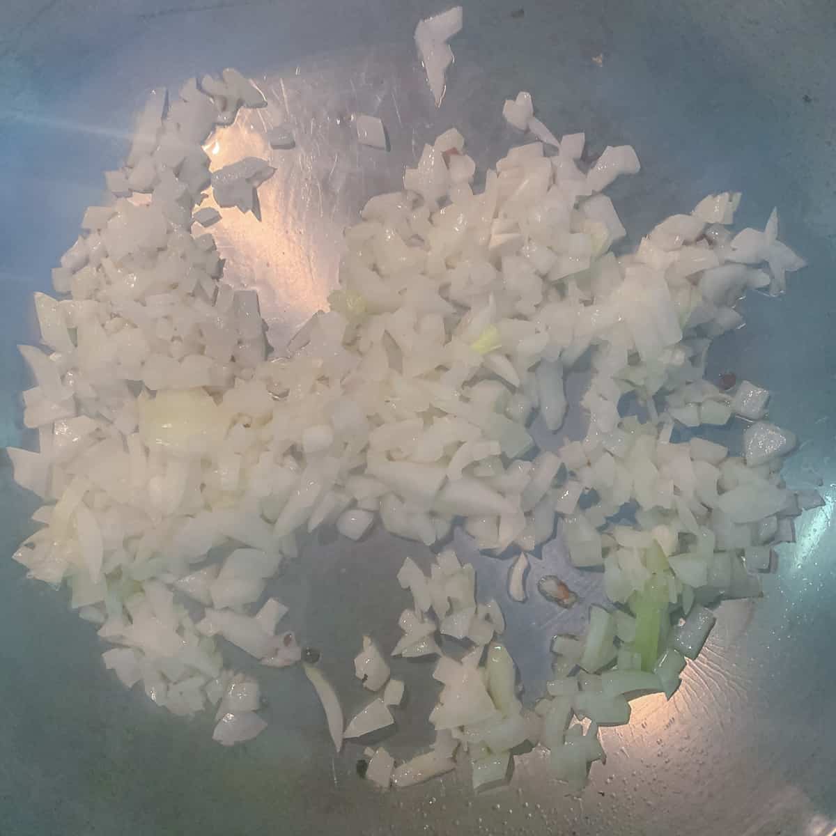 chopped onions in silver pan cooking