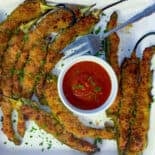 Stuffed Italian long hots on white plate with marinara sauce for dipping