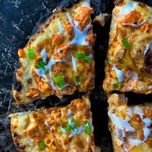 flour slices of buffalo chicken pizza on pizza pan overhead view