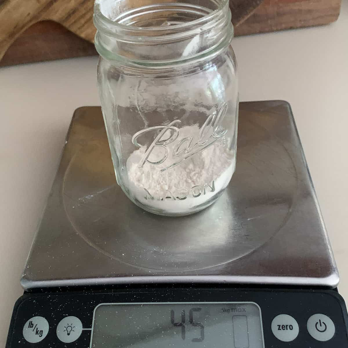 front view of ball jar on scale measuring flour ingredient at 45 grams