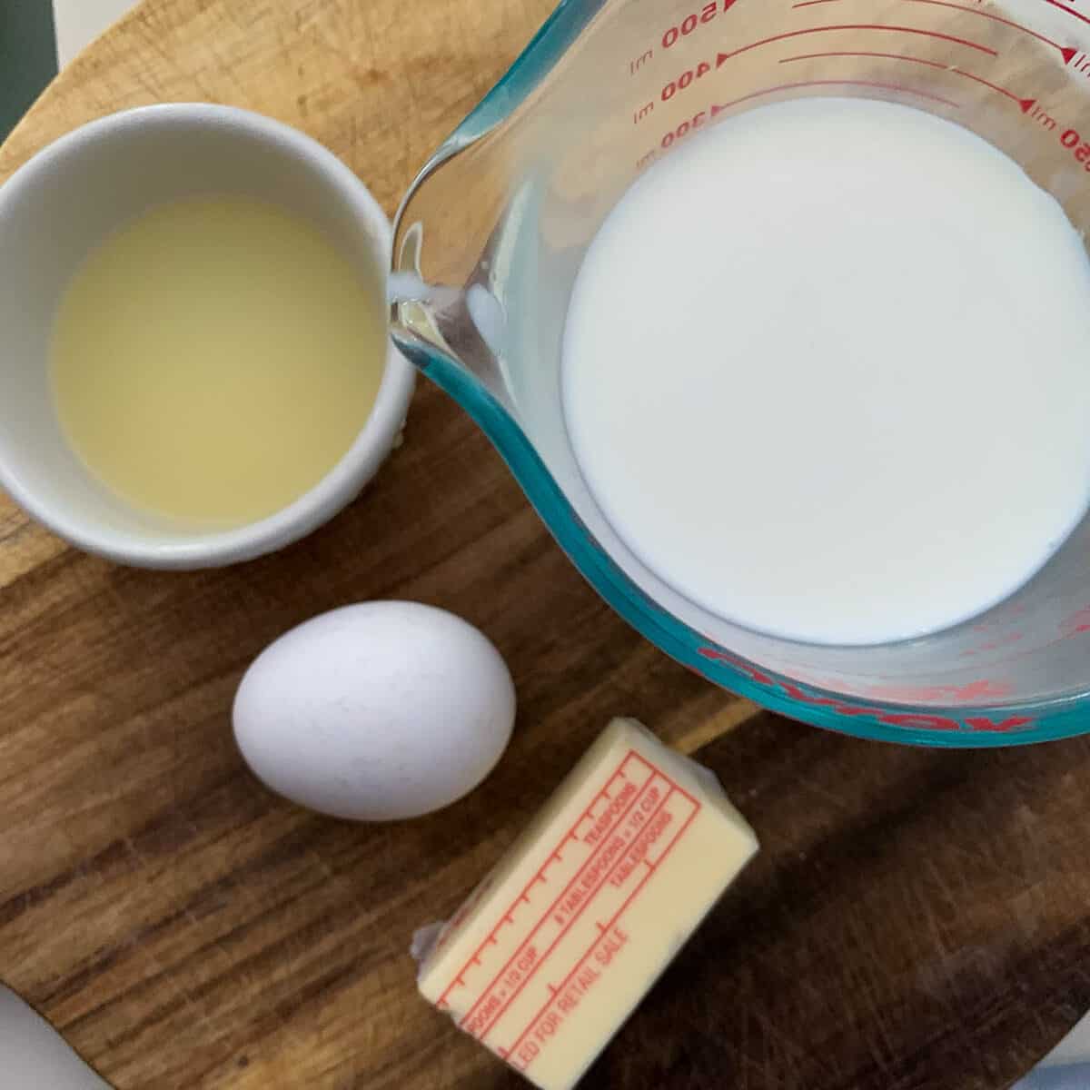 shokupan wet ingredients on wooden board (egg, milk, butter and optional lemon juice)