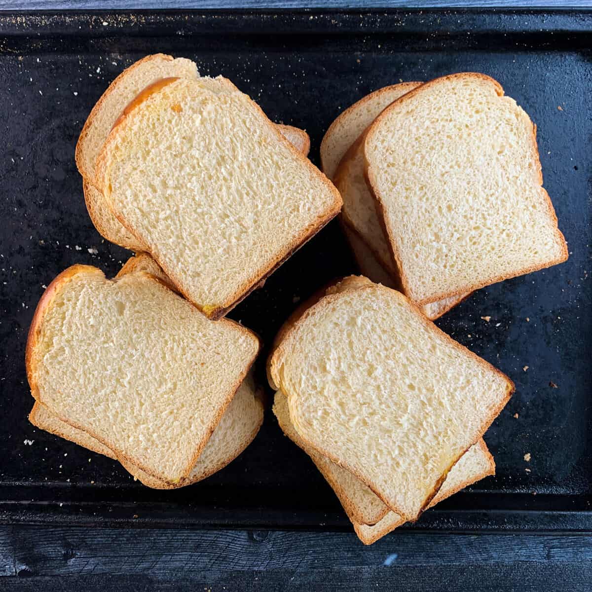 slices of shokupan (sandwich bread) on black baking tray