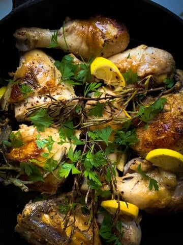 top view of skillet roasted chicken with herbs and lemon