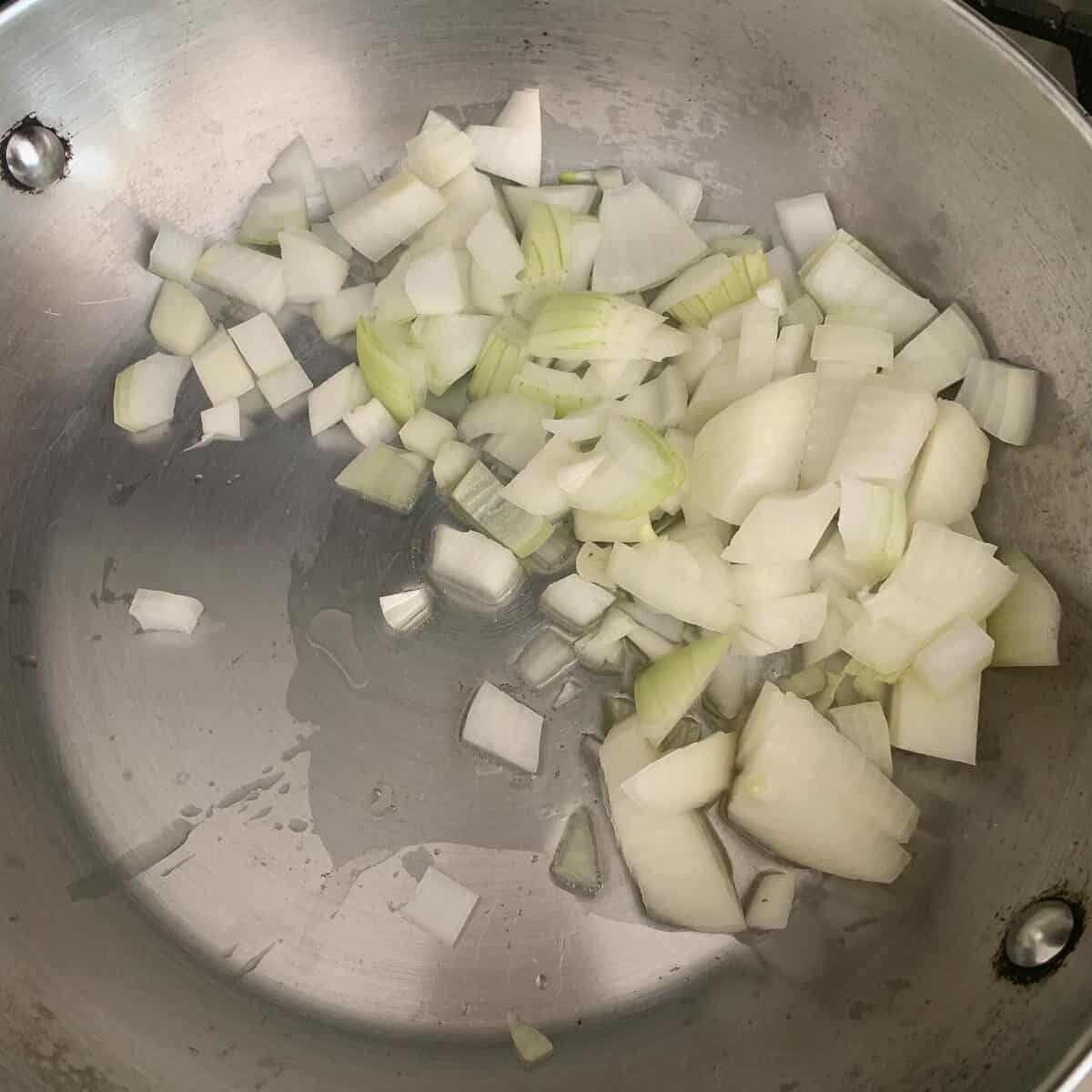 raw chopped onion with olive oil in pan