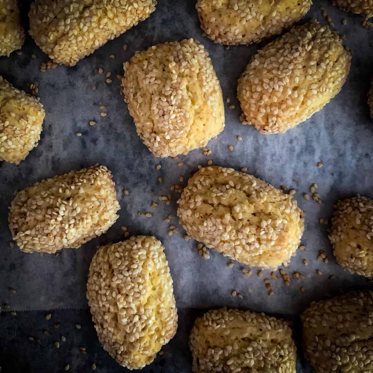 baked Italian sesame seed cookies on parchment lined baking sheet