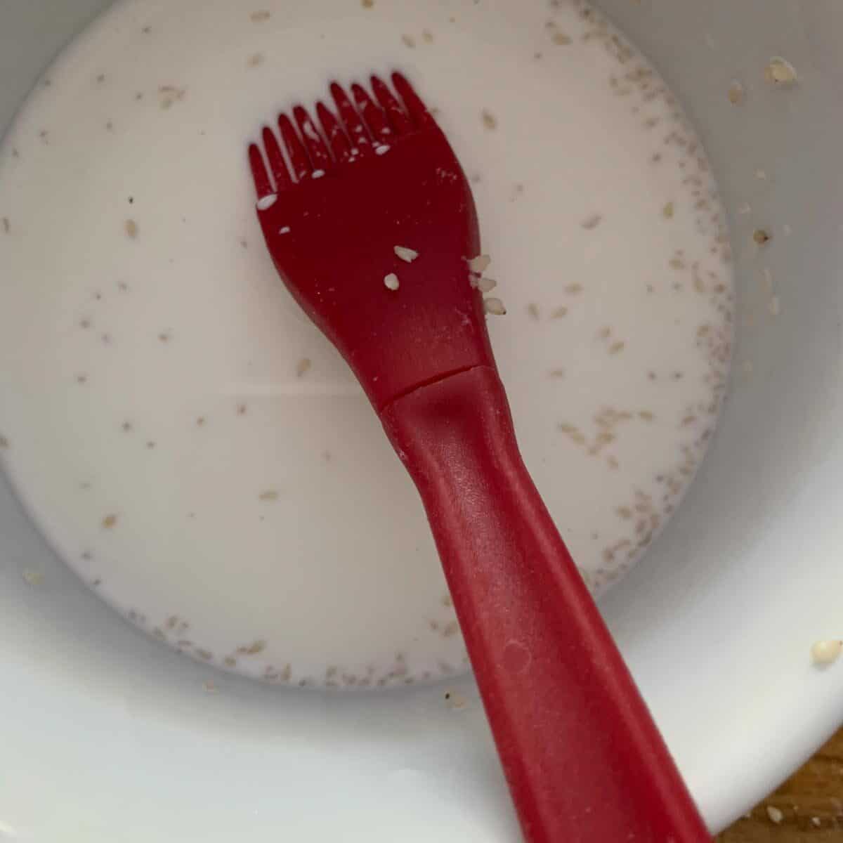 bowl of milk with brush for painting cookies with milk