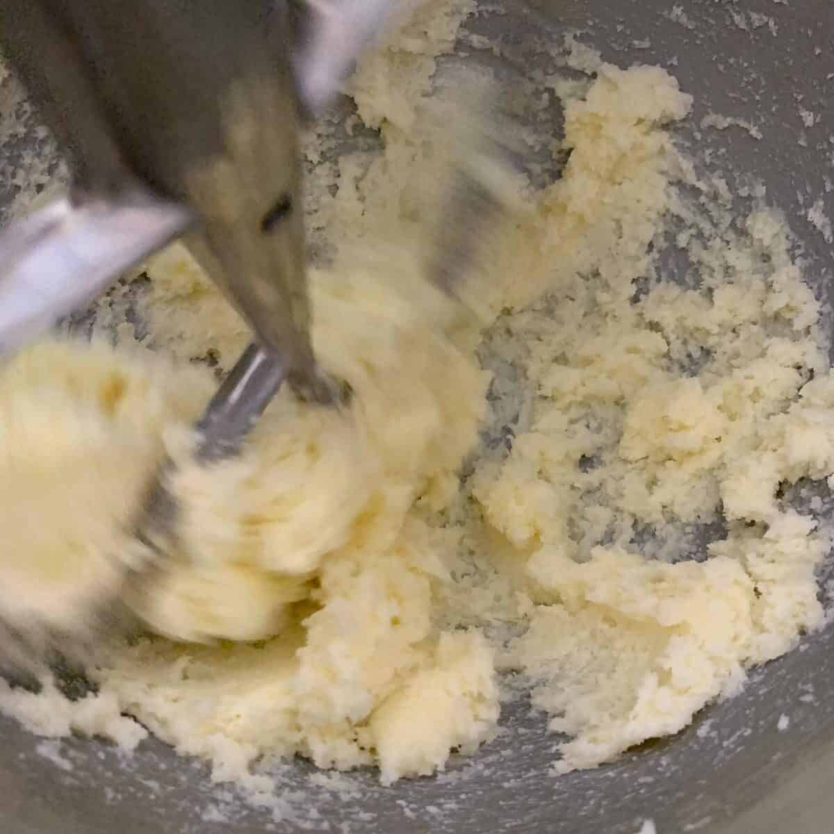 close up of cookie dough being mixed in standing mixer