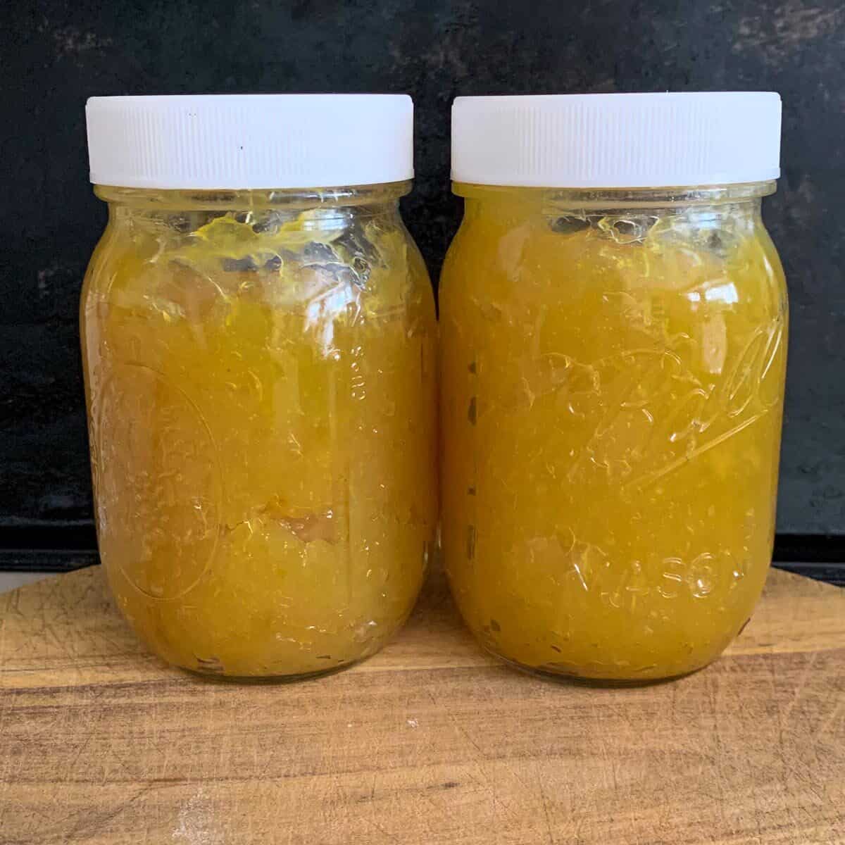two small jars of lemon paste on wooden board