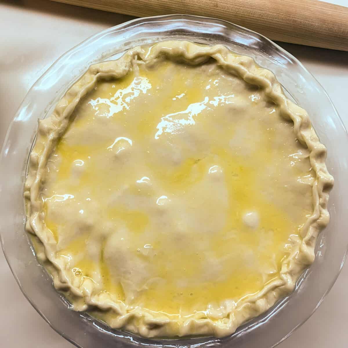 unbaked pie topped with top crust