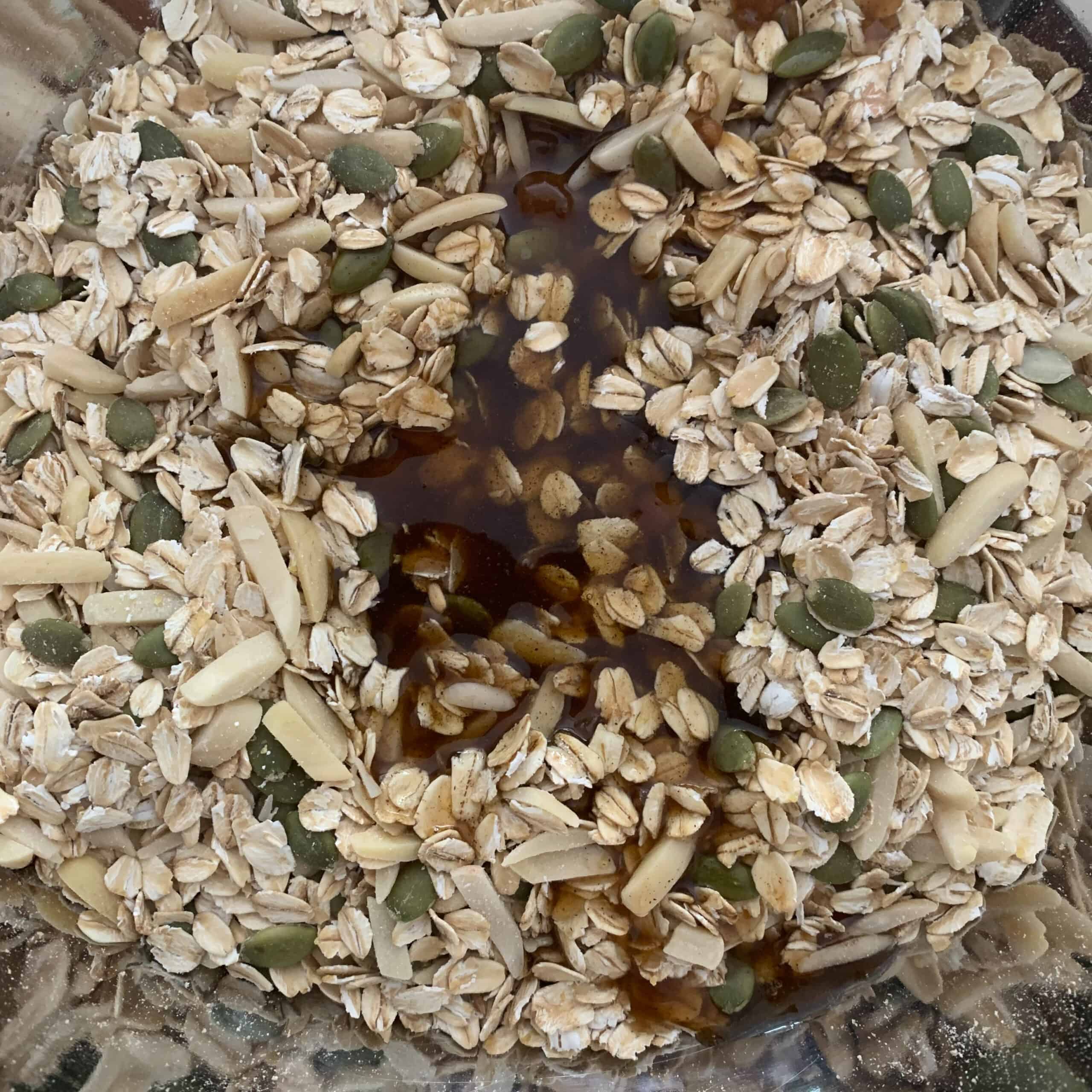 close up of granola making in process; wet ingredients just poured into center of raw granola
