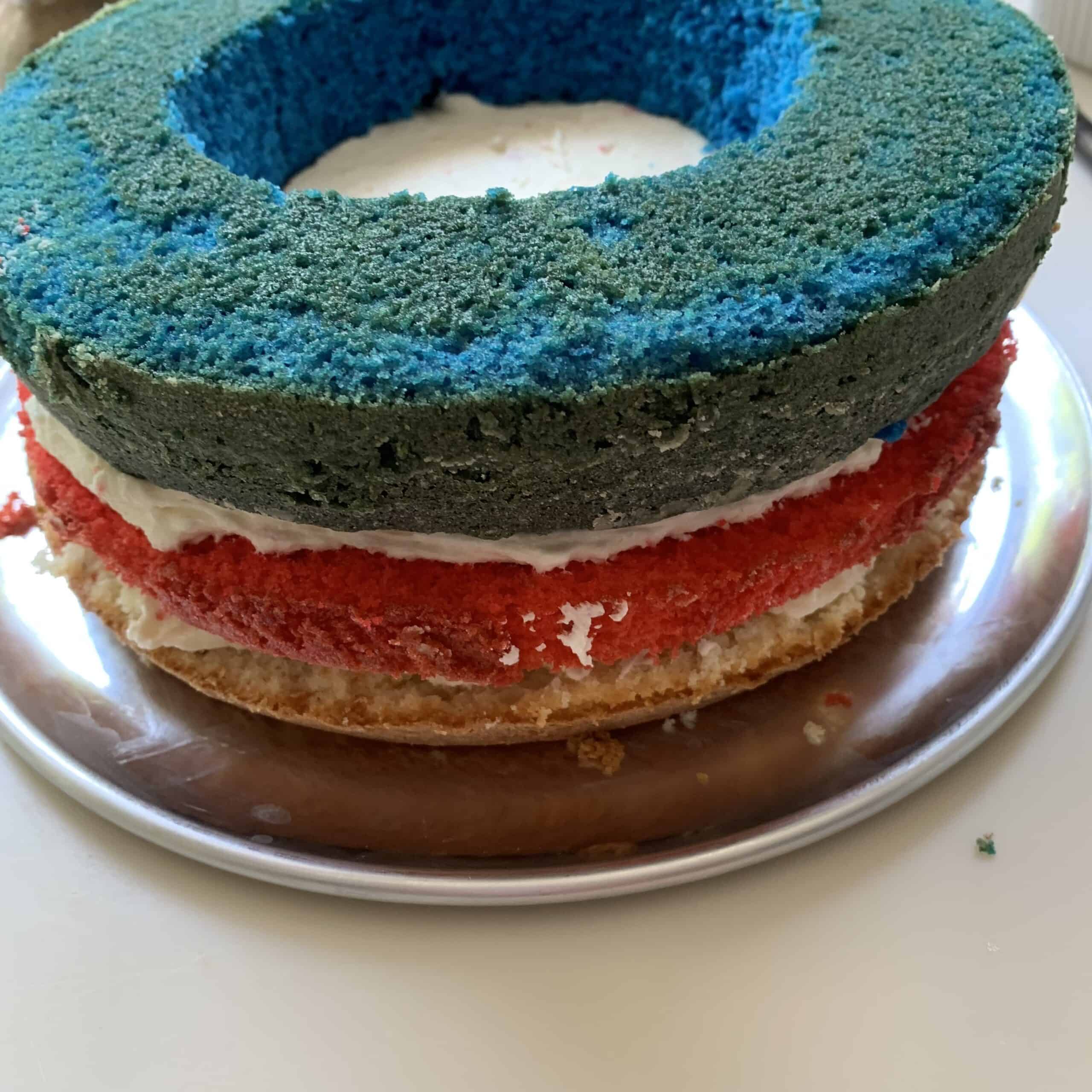 layers of cake: white topped by red topped by blue cake ring layer