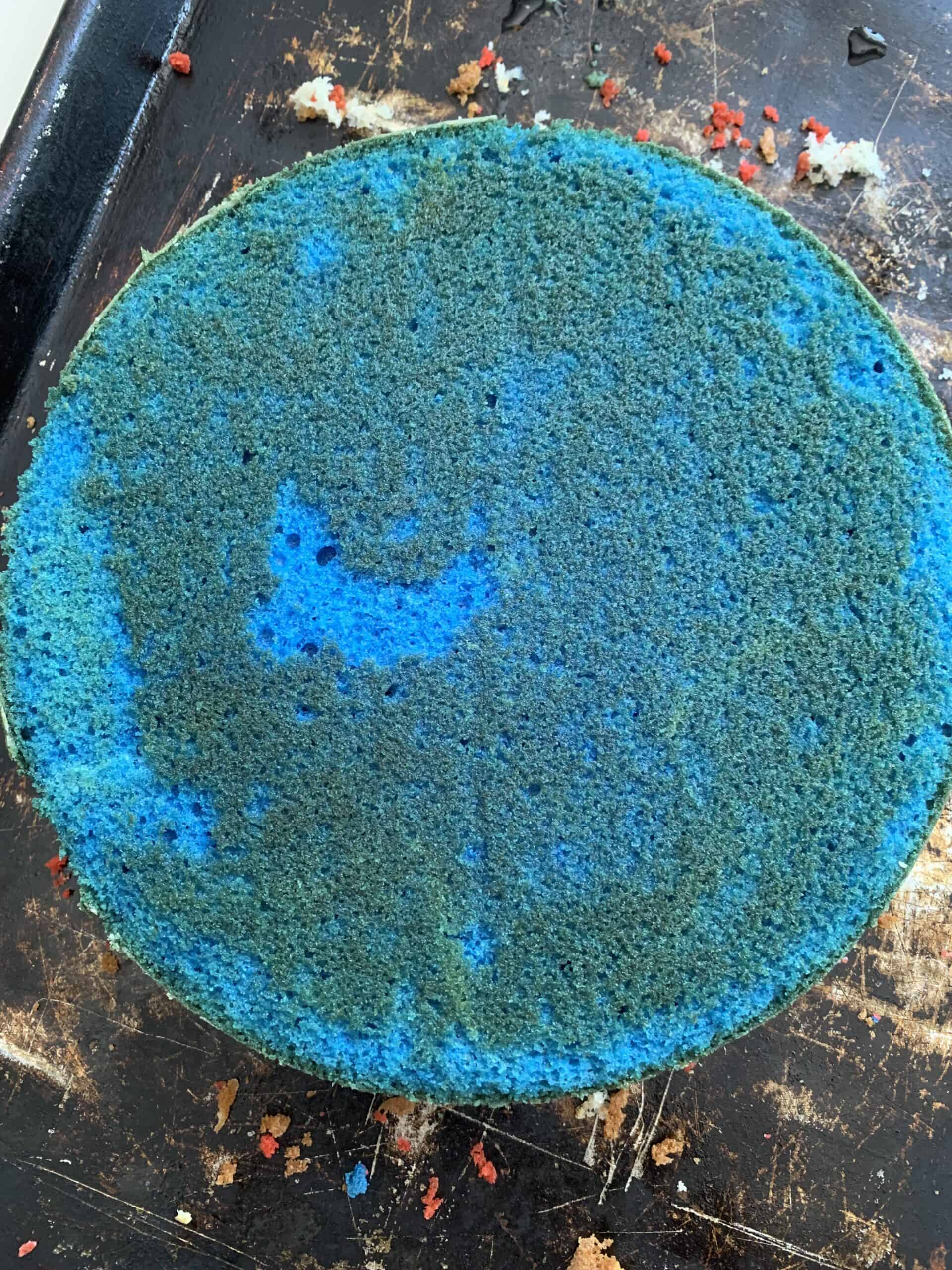 blue cake layer on black baking sheet
