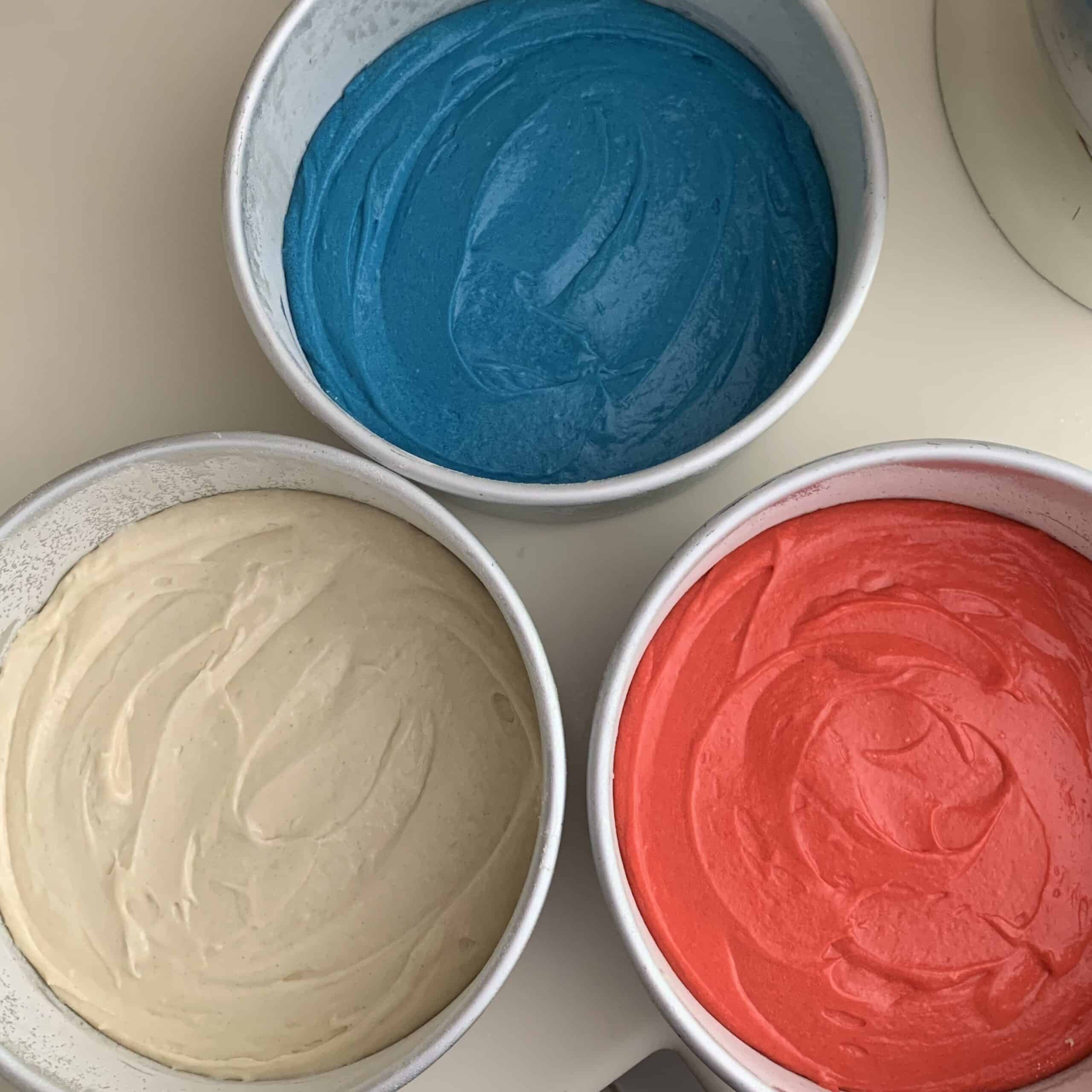three cake pans with red white and blue batter