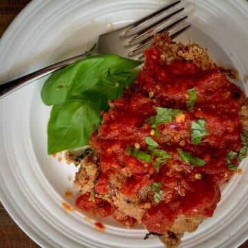top view of baked eggplant parm on white dish with fork