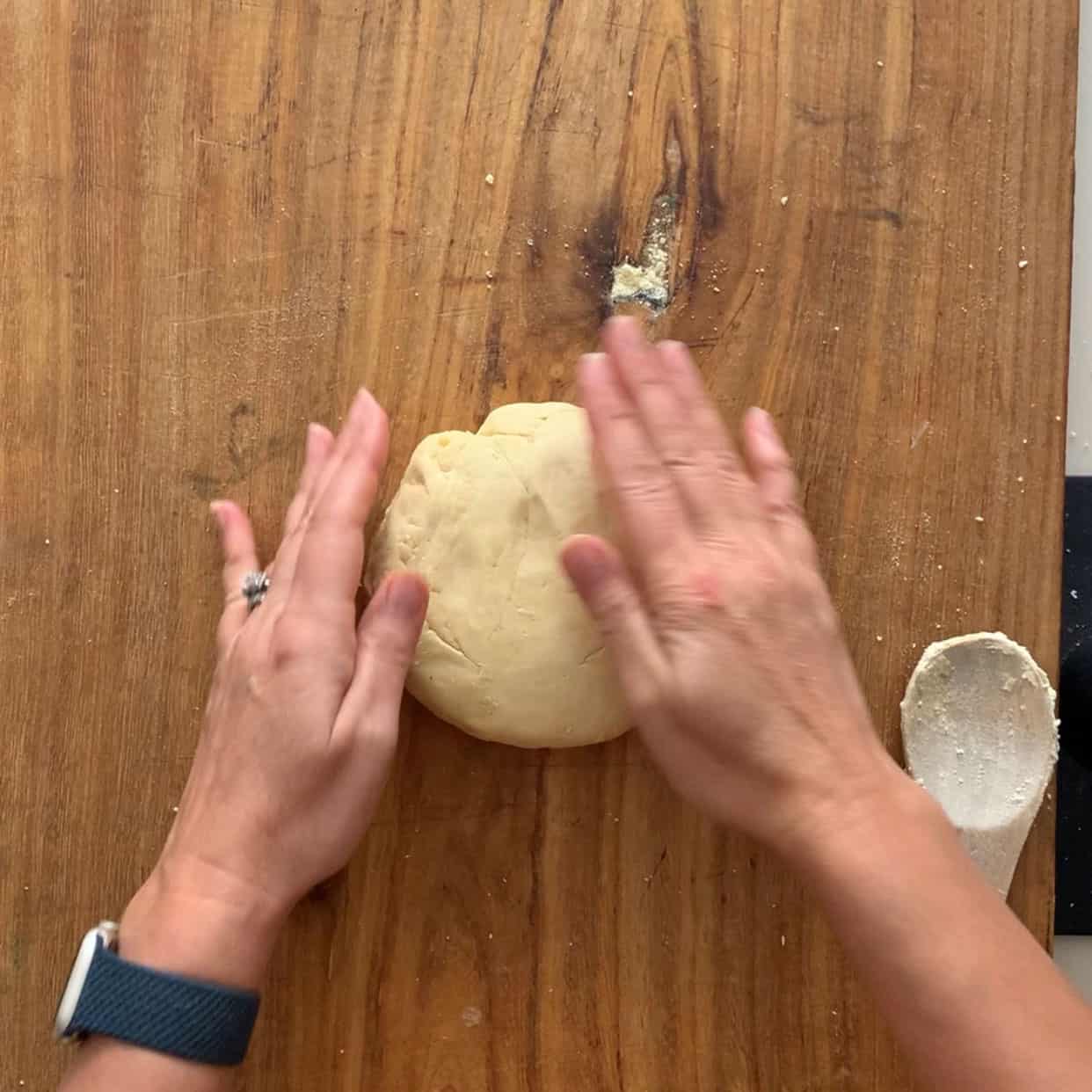 kneading pasta dough on wooden board