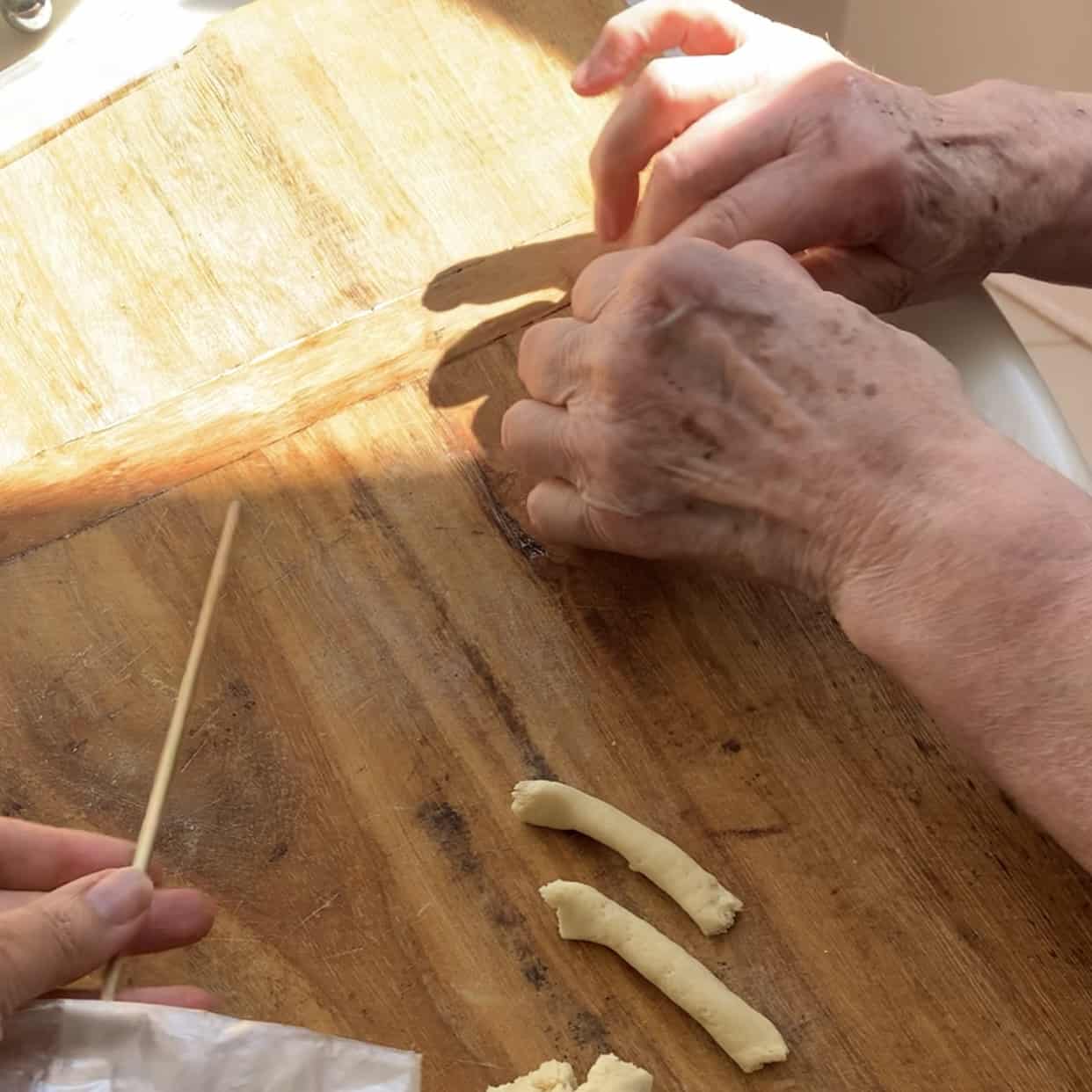 pinching off pieces of rope (dough) to make fusilli